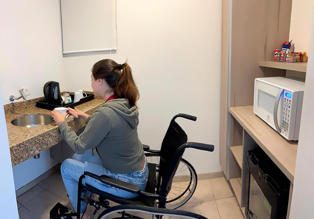 래디슨 오스카 프레이레 호텔 상파울루 외부 사진 A disabled woman in a wheelchair using a microwave oven
