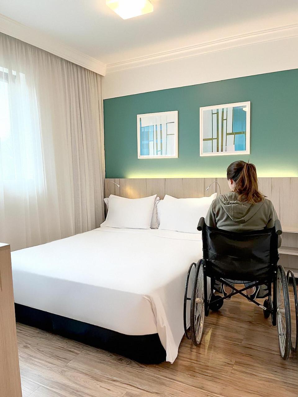 래디슨 오스카 프레이레 호텔 상파울루 외부 사진 A disabled woman in a wheelchair in a hotel room