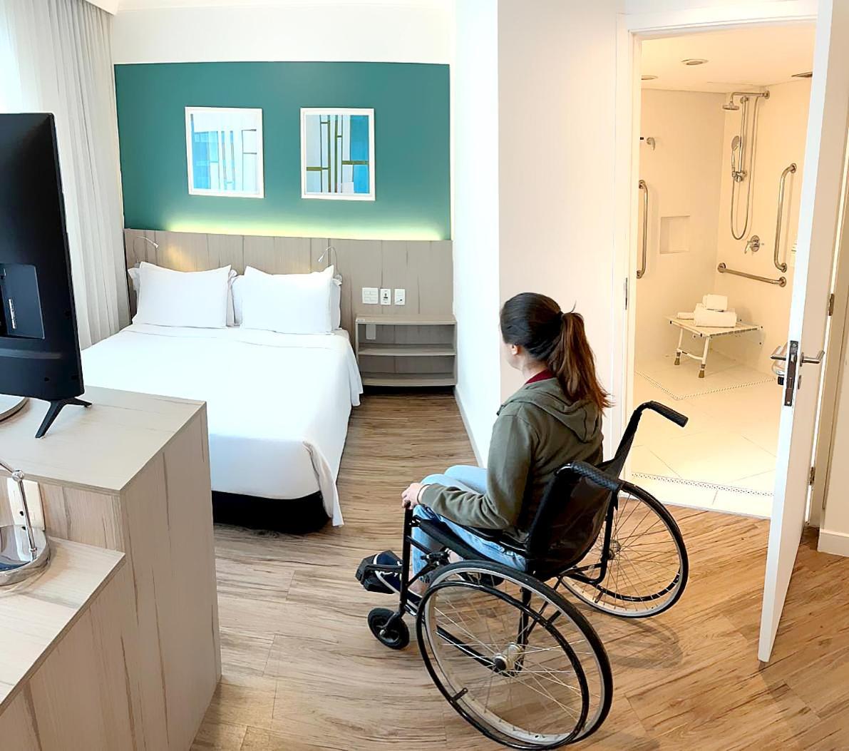 래디슨 오스카 프레이레 호텔 상파울루 외부 사진 A disabled woman in a wheelchair in a hotel room